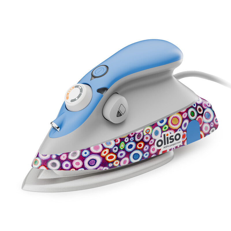 Kaffe Fassett M3Pro Project Iron by Oliso shown in side view, featuring his bold roman glass pattern in vibrant purples, blues, and reds with signature blue handle