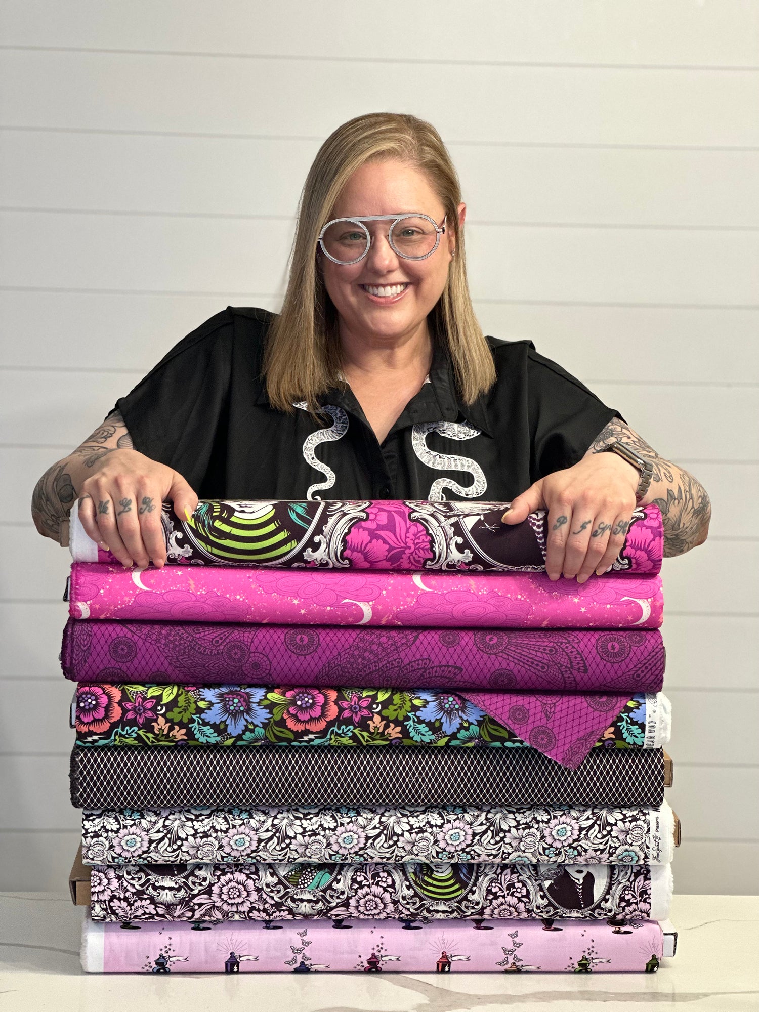 Tula Pink with a stack of her fabrics