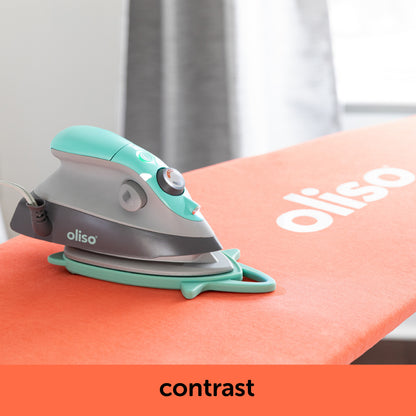 Image showing how the aqua oliso M3Pro project iron contrast with the coral ironing board cover. Each is sold separately.