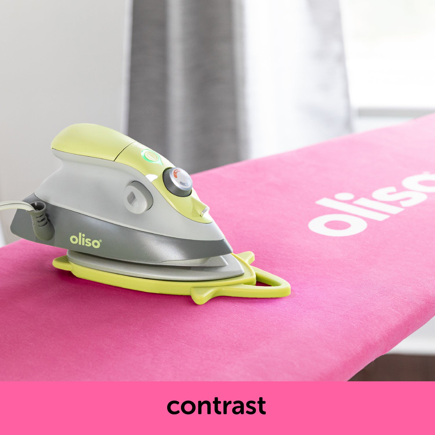 Image showing how the pistachio oliso M3Pro project iron contrasts with the raspberry ironing board cover. Each is sold separately.